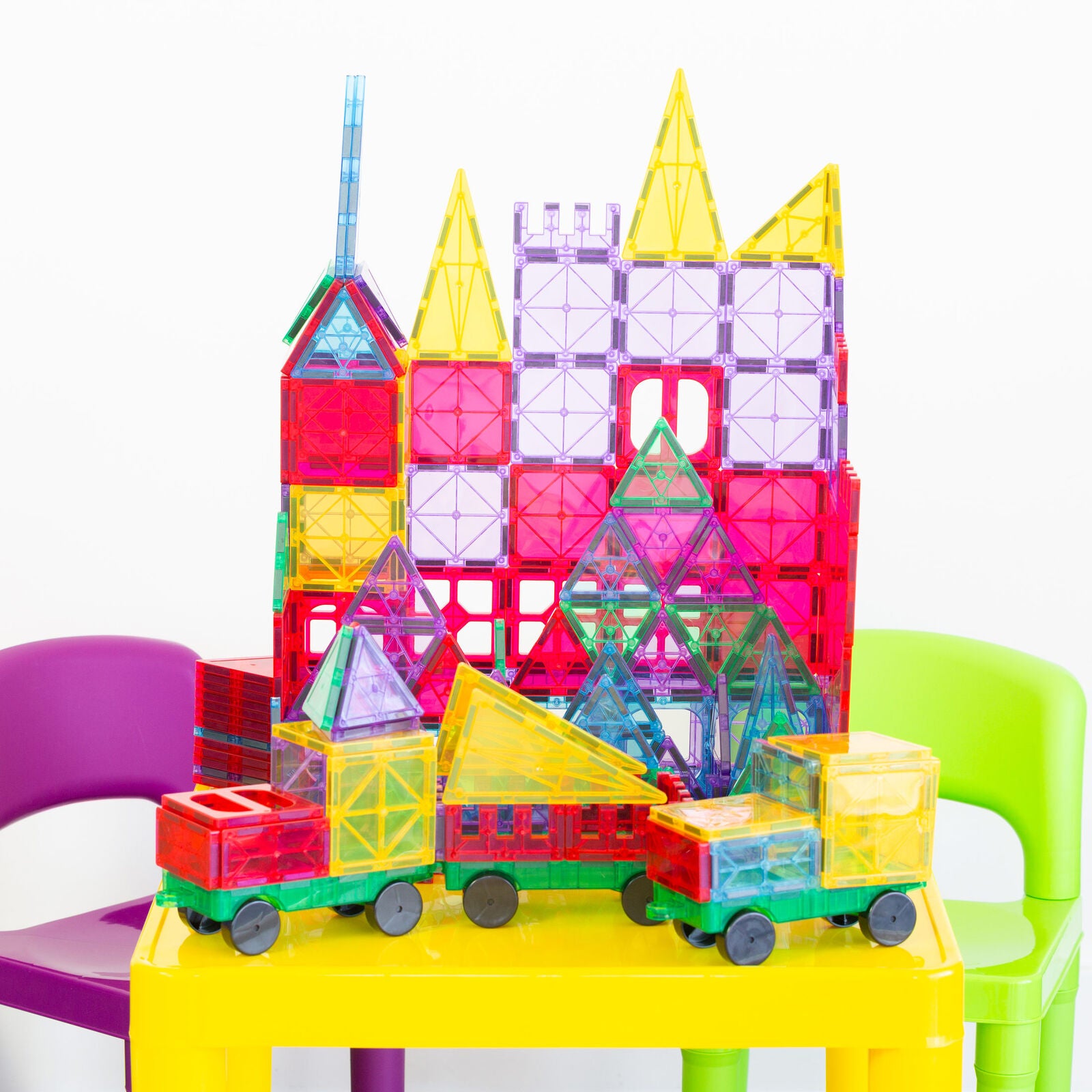 Colorful magnetic building blocks on a yellow table with chairs around
