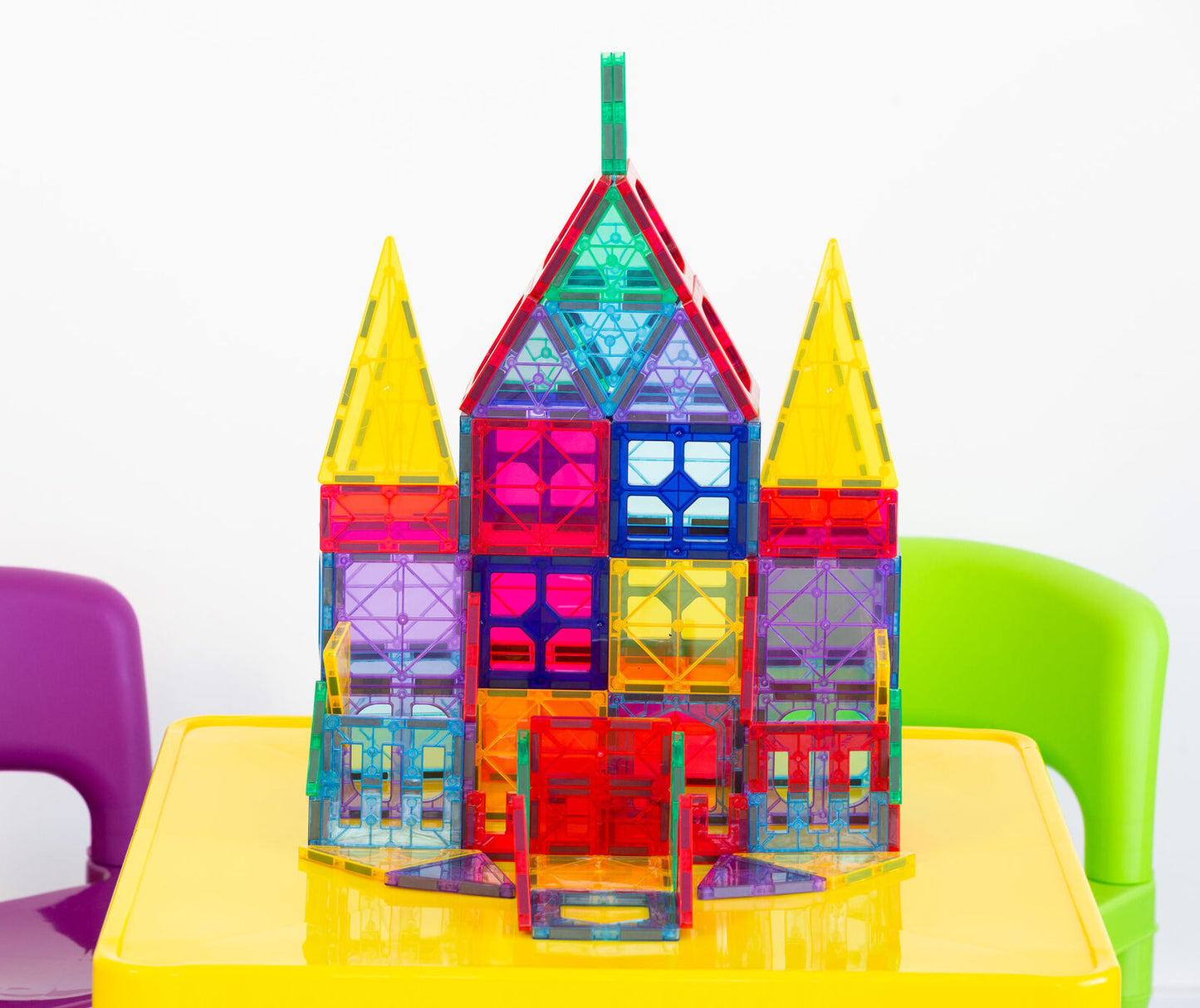 Colorful magnetic building block set on a yellow table with a white background